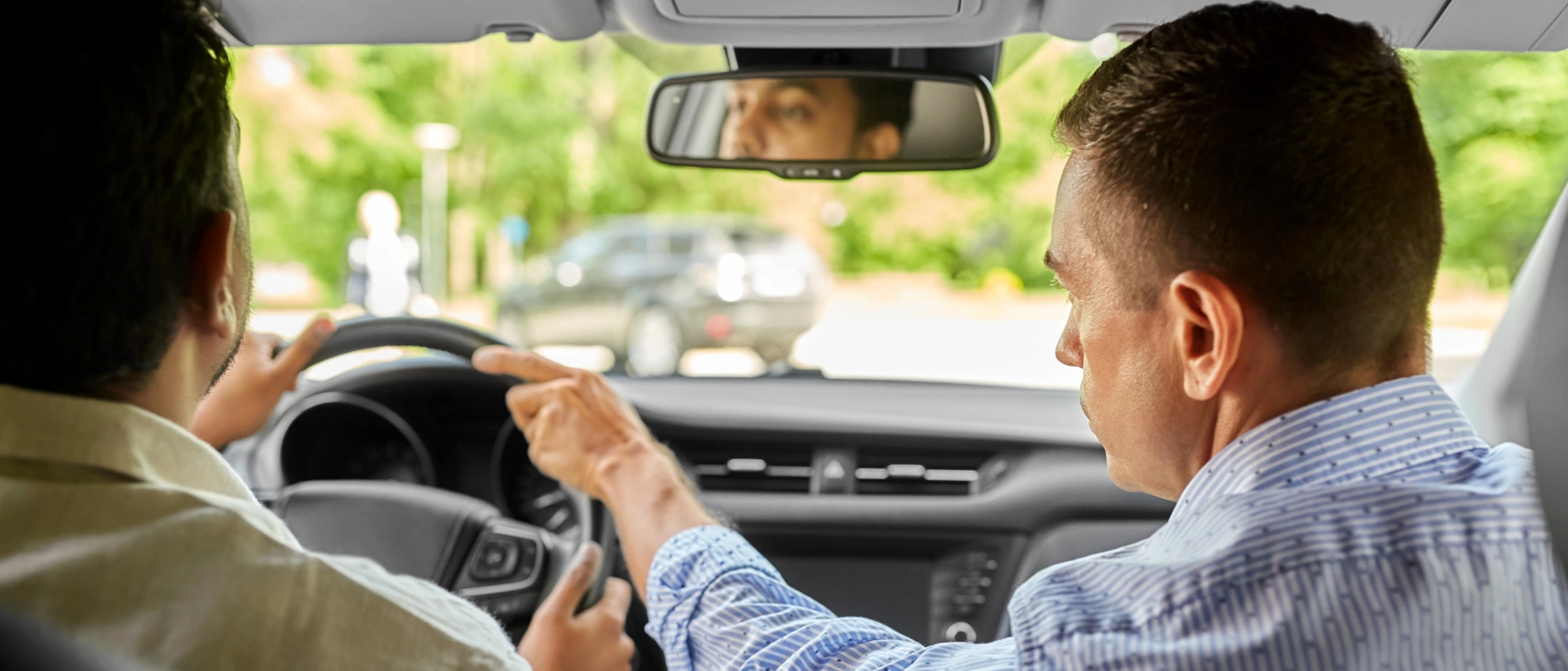 Praxisstunde mit Fahrlehrer Fahrlehrer sitzt neben dem Fahrschüler und gibt ihm während der Fahrt Anweisungen
