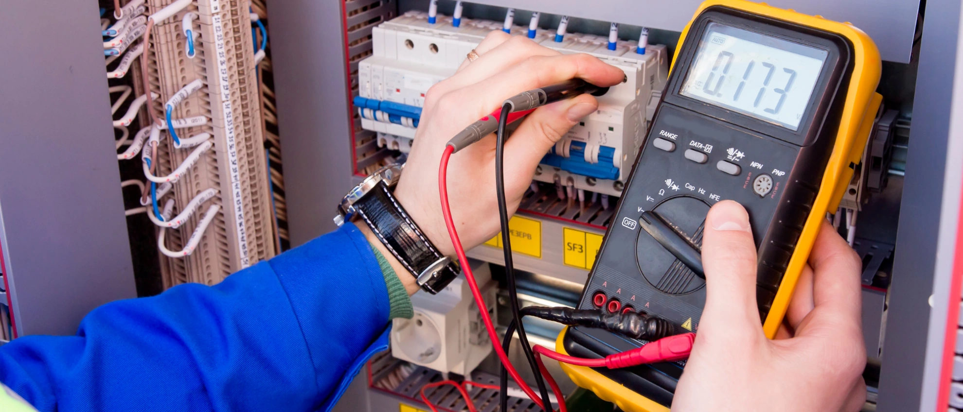 Spannung messen mit Multimeter Elektriker misst Spannung mit einem digitalen Multimeter an einer Elektroverteilung