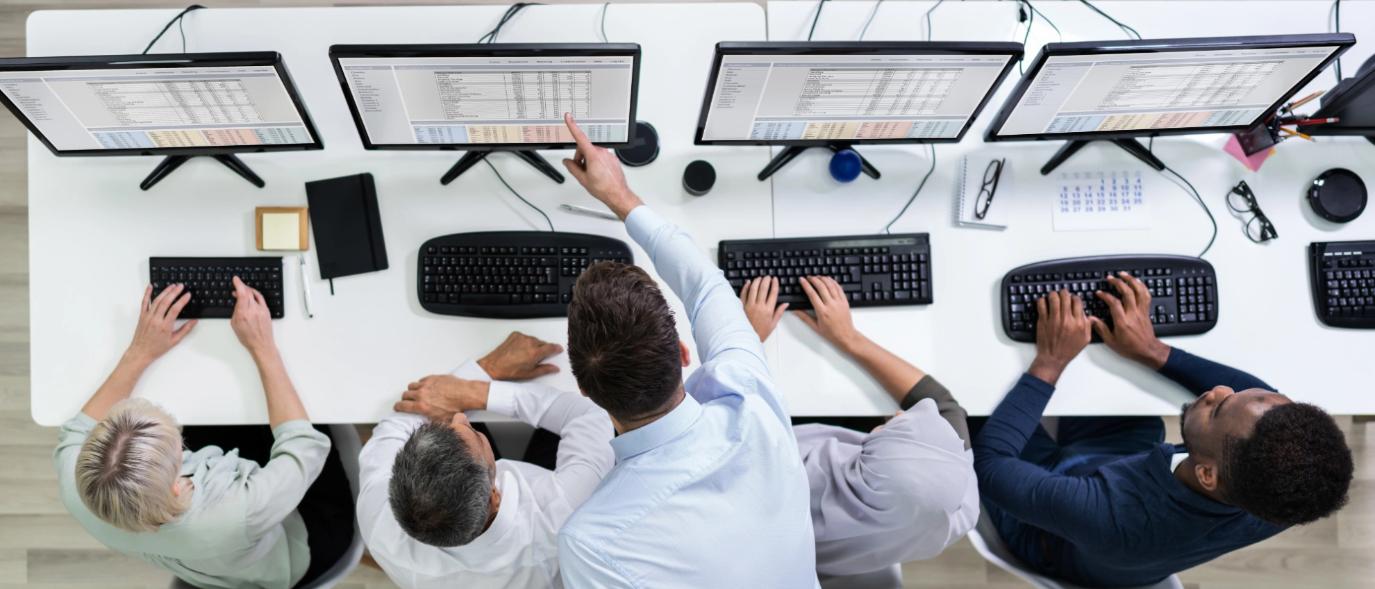 IT-Schulung am Monitor Schulungsteilnehmer arbeiten gemeinsam an mehreren Monitoren in einem modernen Büro