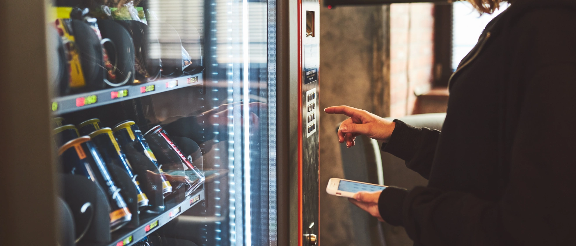 Getränkeautomat mit Smartphone Person nutzt Smartphone zur kontaktlosen Zahlung an einem Getränkeautomaten