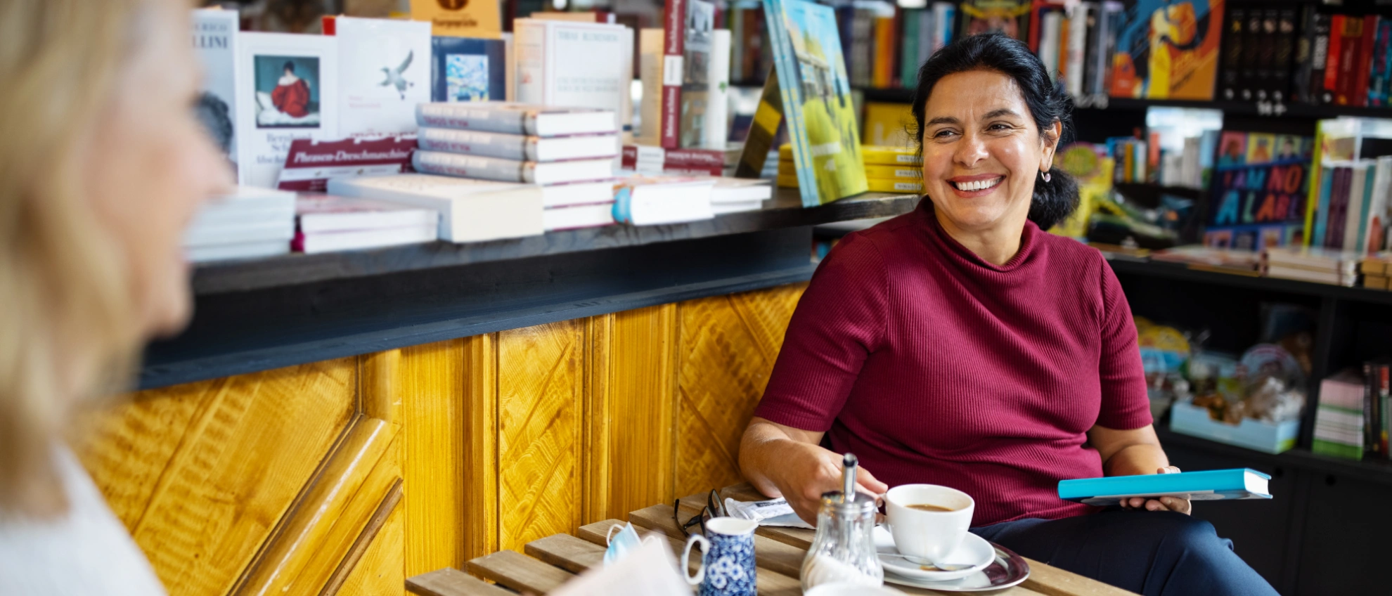 Gespräch bei Kaffee und Büchern Autorin oder Buchhändlerin im Gespräch bei einem Kaffee zwischen Büchern