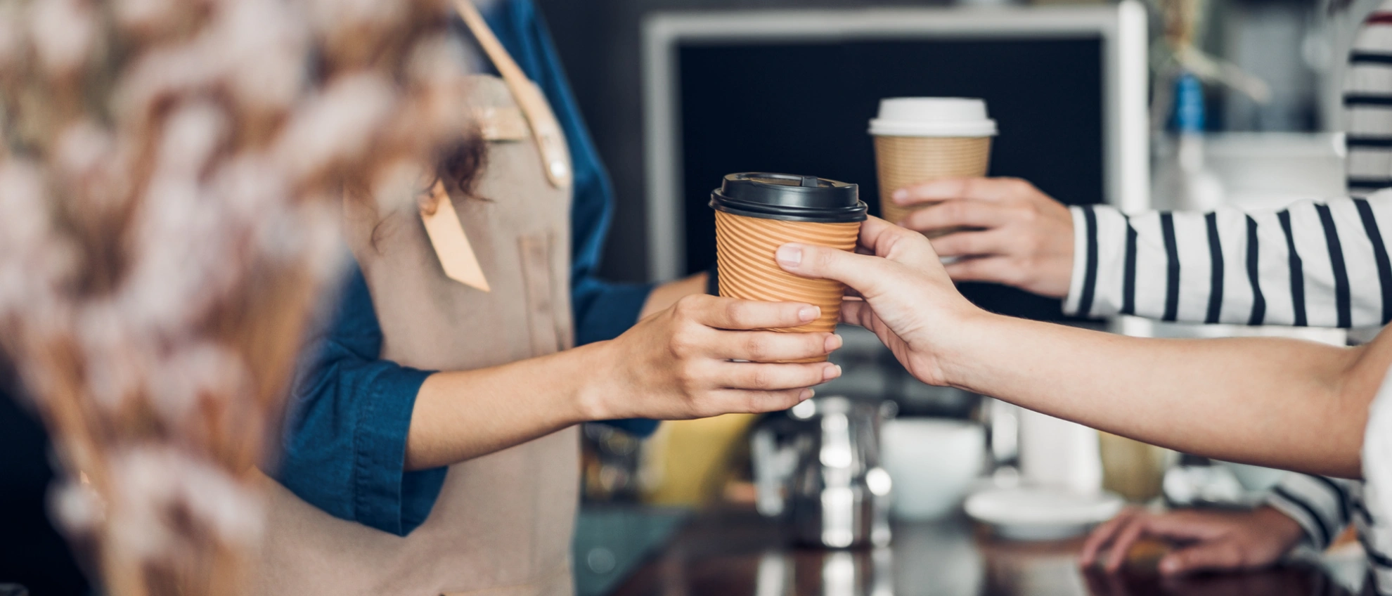 Kaffeebecher-To-Go im Café Menschen stoßen mit Coffee-to-Go-Bechern an – Szene aus einem Café