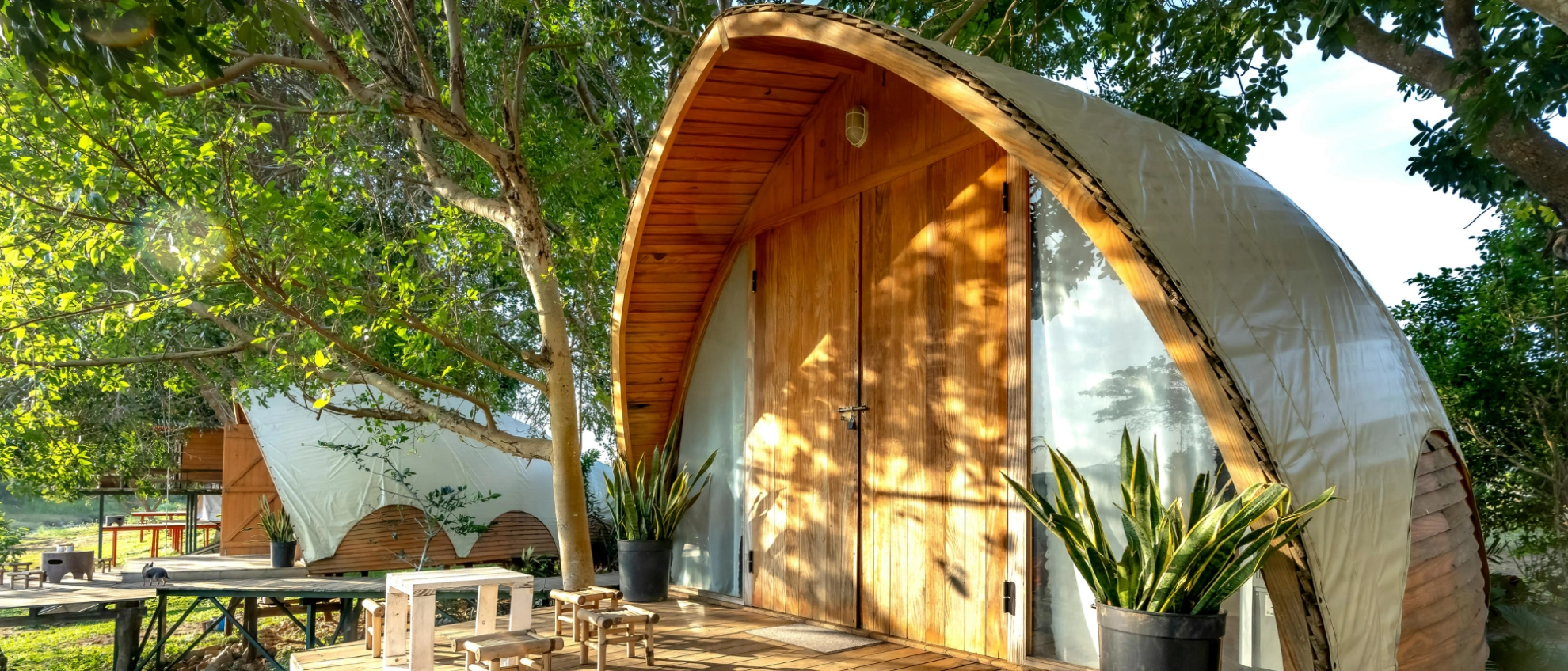 Architektonisches Glamping-Domizil im Grünen Modernes Tiny House mit rundem Bogendach in natürlicher Umgebung mit Liegestuhl