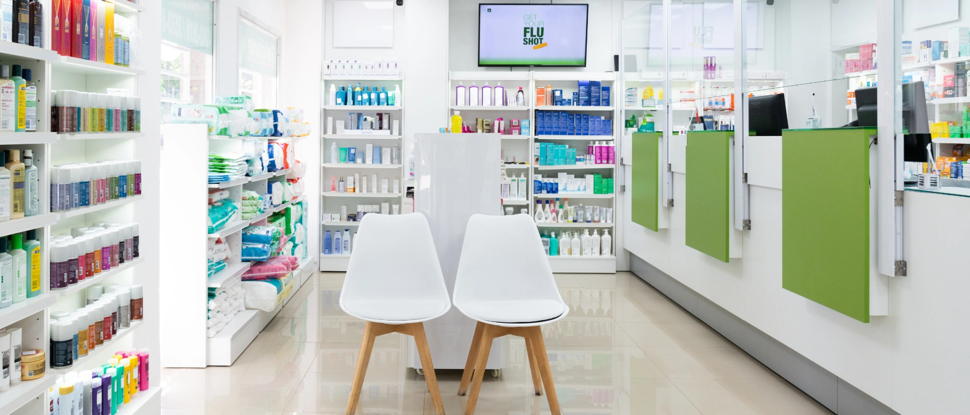 Helle, minimalistisch eingerichtete Apotheke mit zwei weißen Stühlen im Wartebereich