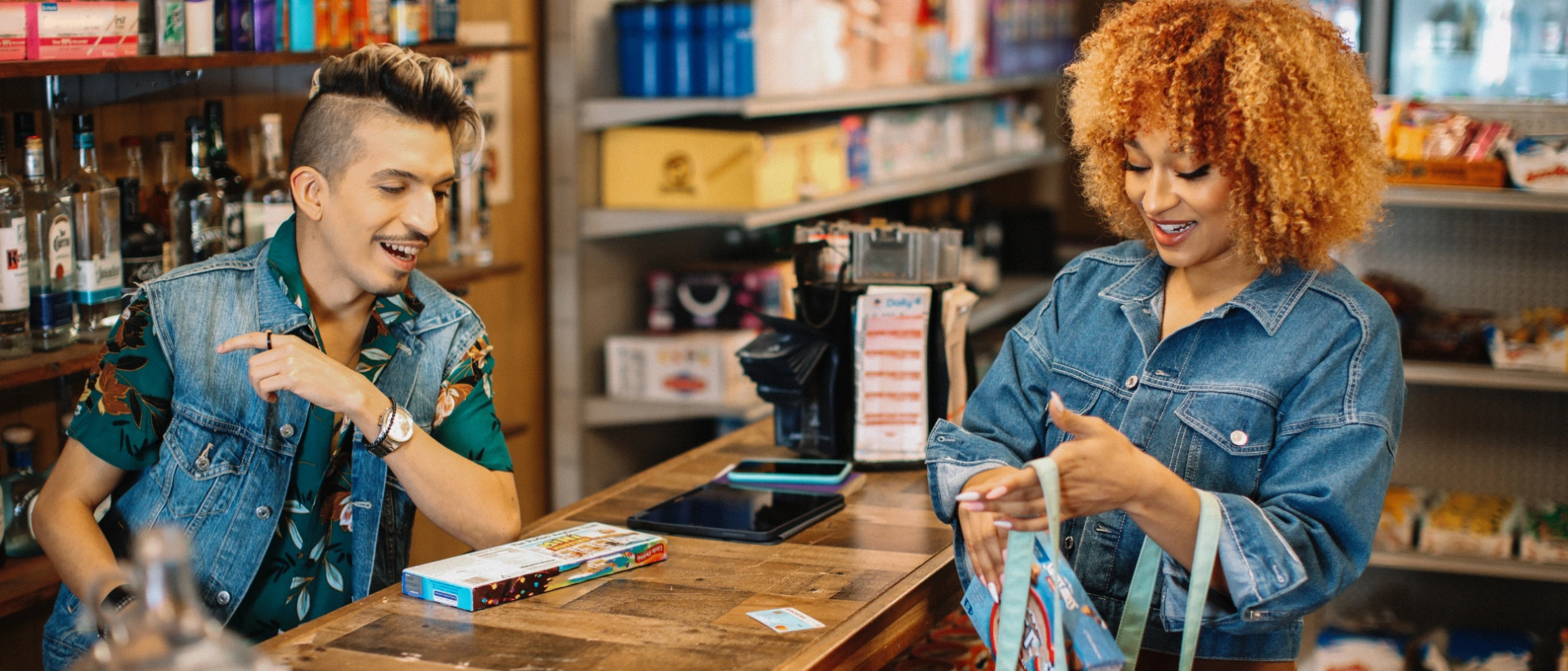 Verkäufer hilft einer Kundin beim Einpacken der Ware im kleinen Geschäft