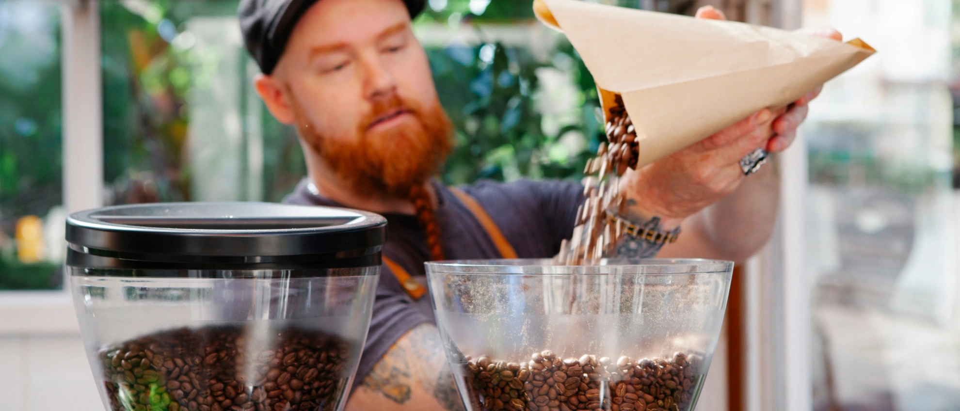 Mann gießt füllt Kaffeebohnen in der Kaffeemaschine auf