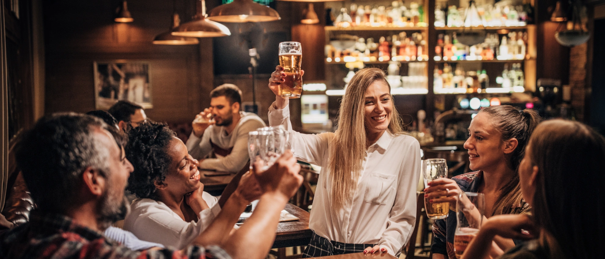 Geselligkeit an der Bar Gruppe von Menschen trinkt und lacht gemeinsam an einer Bar in gemütlicher Atmosphäre