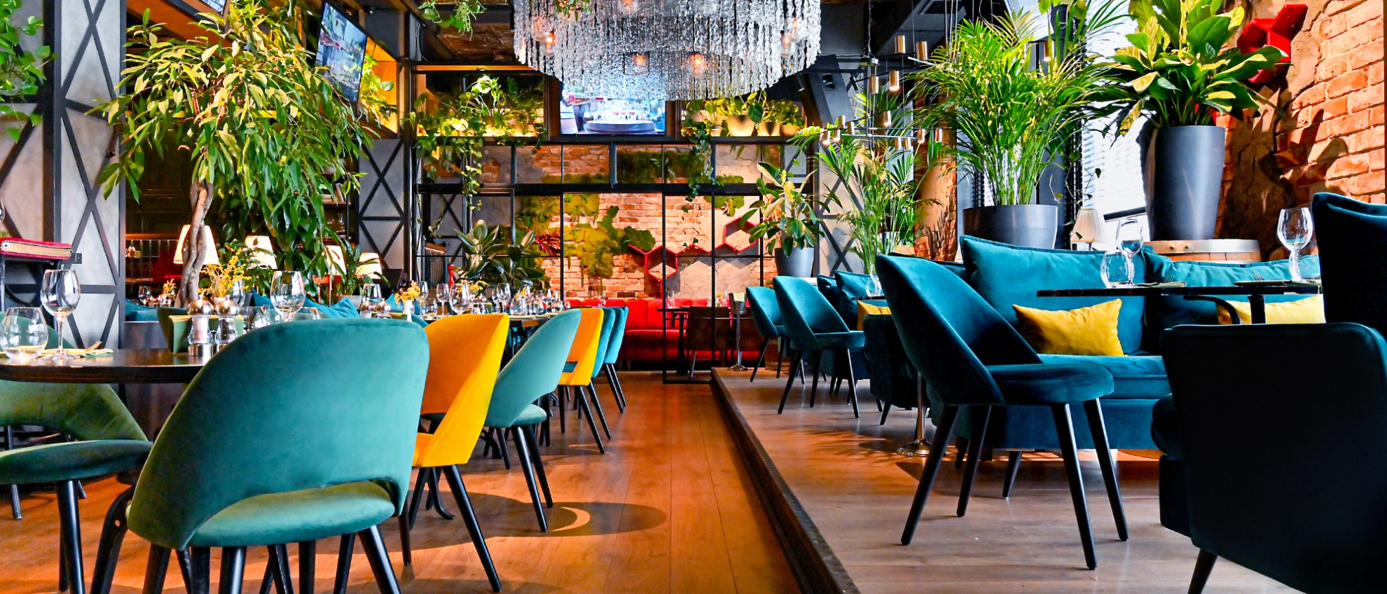 Stilvolles Restaurantinterieur mit Pflanzen und modernen Möbeln Modern eingerichtetes Restaurant mit vielen grünen Pflanzen und stilvollen Tischen und Stühlen