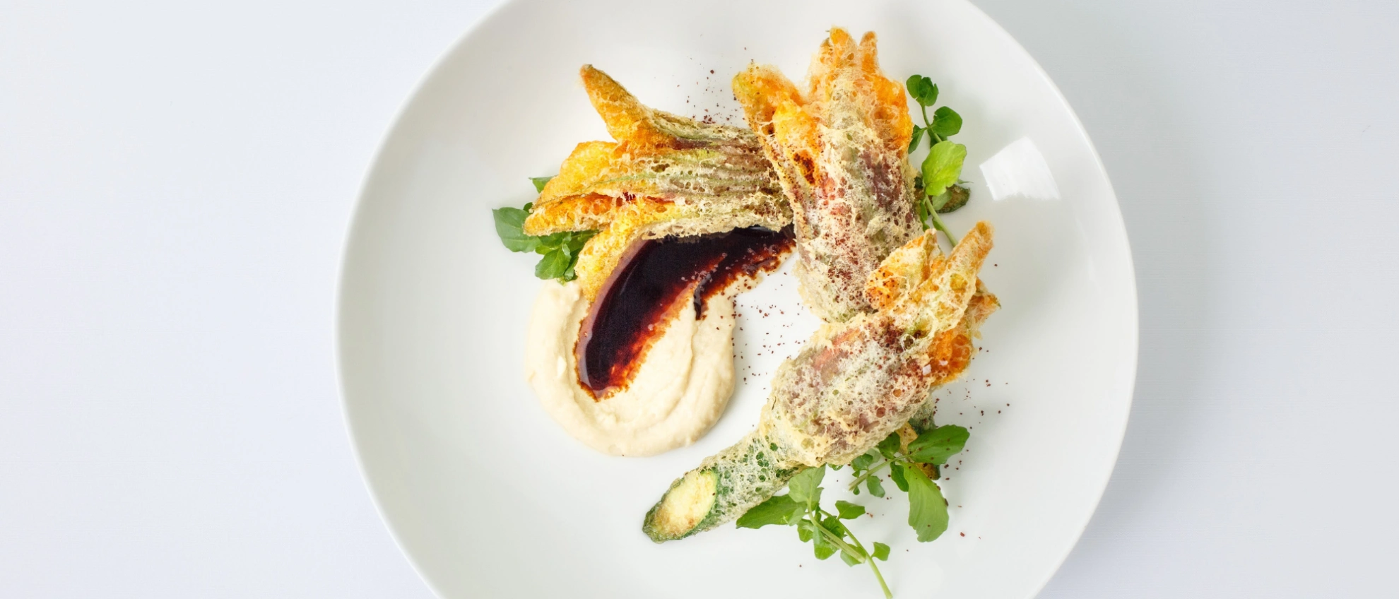 Künstlerisch angerichtetes Fischgericht mit Gemüse Weißer Teller mit edlem Fischgericht, Gemüsebeilage und kreativer Präsentation